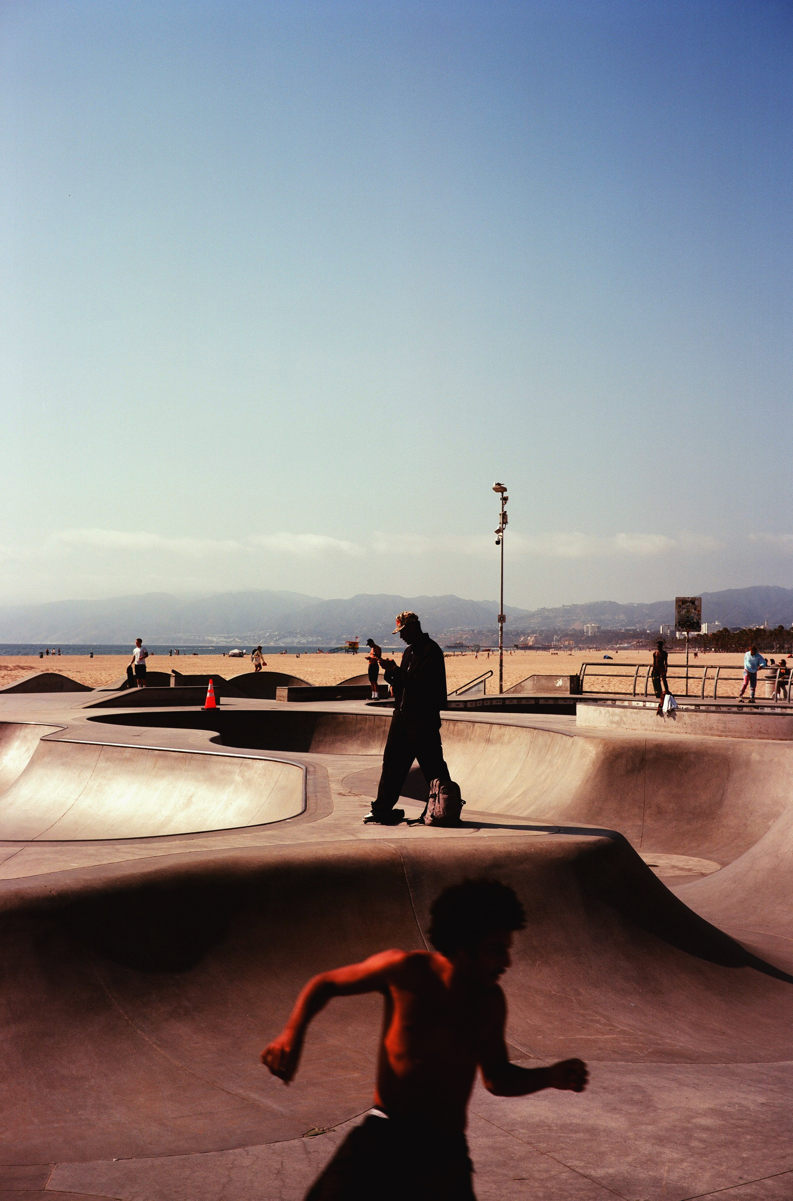 Un skateur en mouvement devant un bowl du skatepark de Venice, Los Angeles